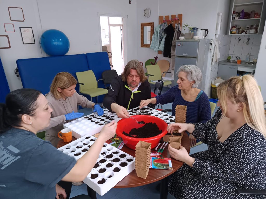 Četiri made žene i muškarac u procesu sadnje 